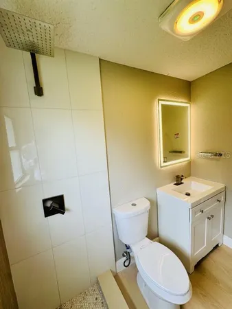 a bathroom with a toilet sink and mirror