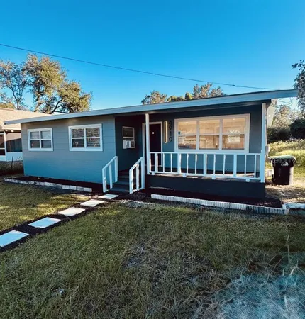 a view of a house with backyard and sitting area