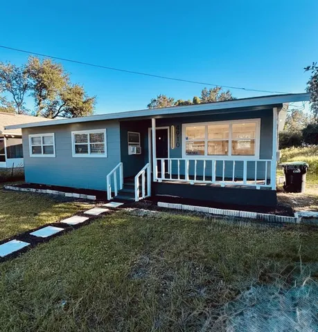 a view of a house with backyard and sitting area