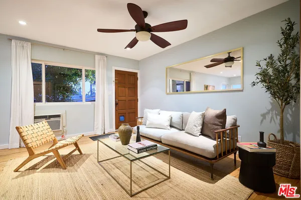 a living room with furniture and a ceiling fan