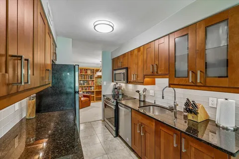 a kitchen with granite countertop a sink and cabinets