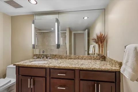 a bathroom with a granite countertop sink and a mirror