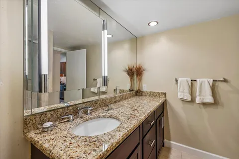 a bathroom with a granite countertop sink and a mirror