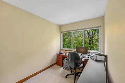 a view of a workspace with furniture and a window