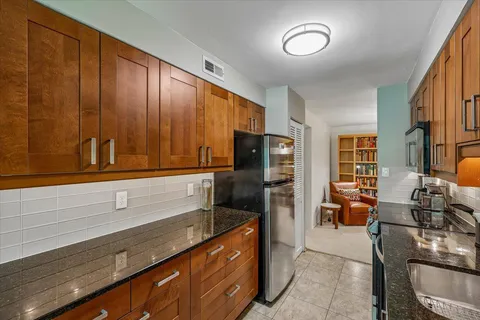 a kitchen with stainless steel appliances granite countertop a refrigerator and a stove