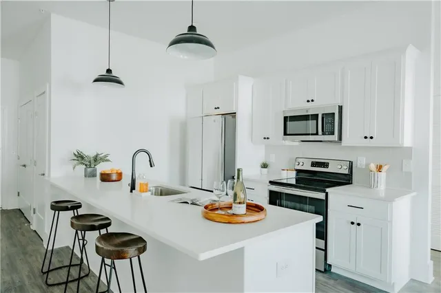 a kitchen with stainless steel appliances a sink stove and refrigerator