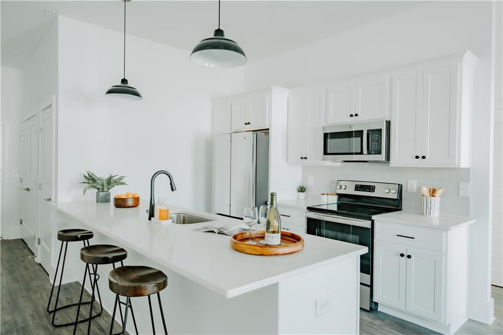 117 Mayson Avenue Northeast, Unit C Atlanta, GA 30307 - Photo 4 of 30 a kitchen with stainless steel appliances a sink stove and refrigerator