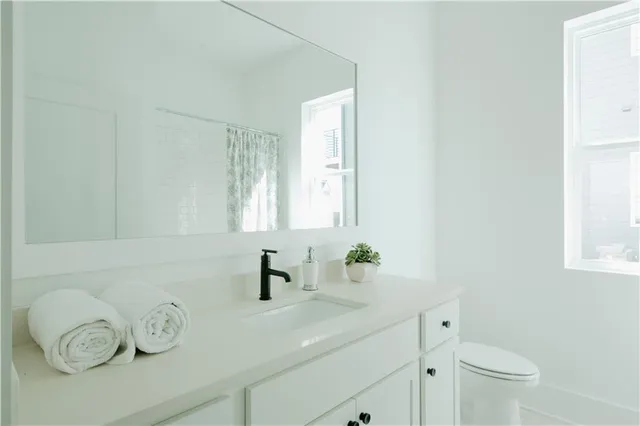 a bathroom with a sink a toilet and mirror