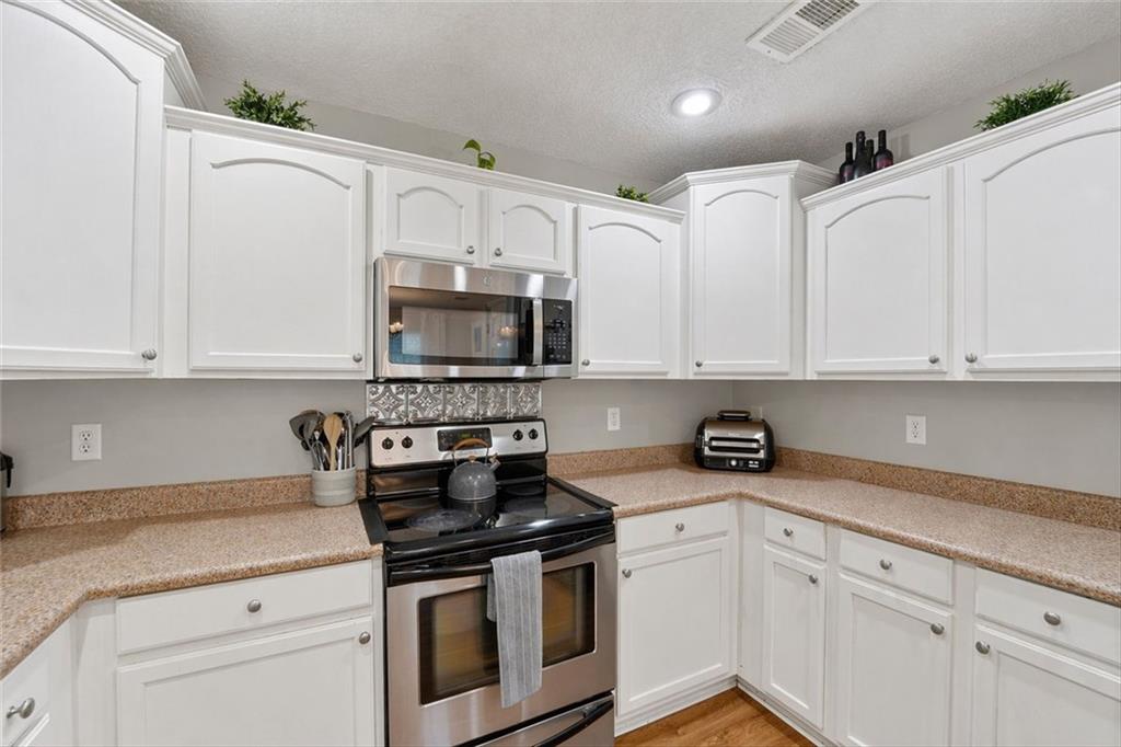 359 Poole Road Ludowici, GA 31316 - Photo 12 of 49 a kitchen with white cabinets stainless steel appliances and sink