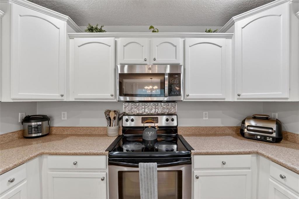359 Poole Road Ludowici, GA 31316 - Photo 13 of 49 a kitchen with white cabinets and a stove top oven