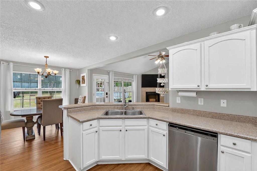 359 Poole Road Ludowici, GA 31316 - Photo 10 of 49 a kitchen with granite countertop a sink and white cabinets with wooden floor