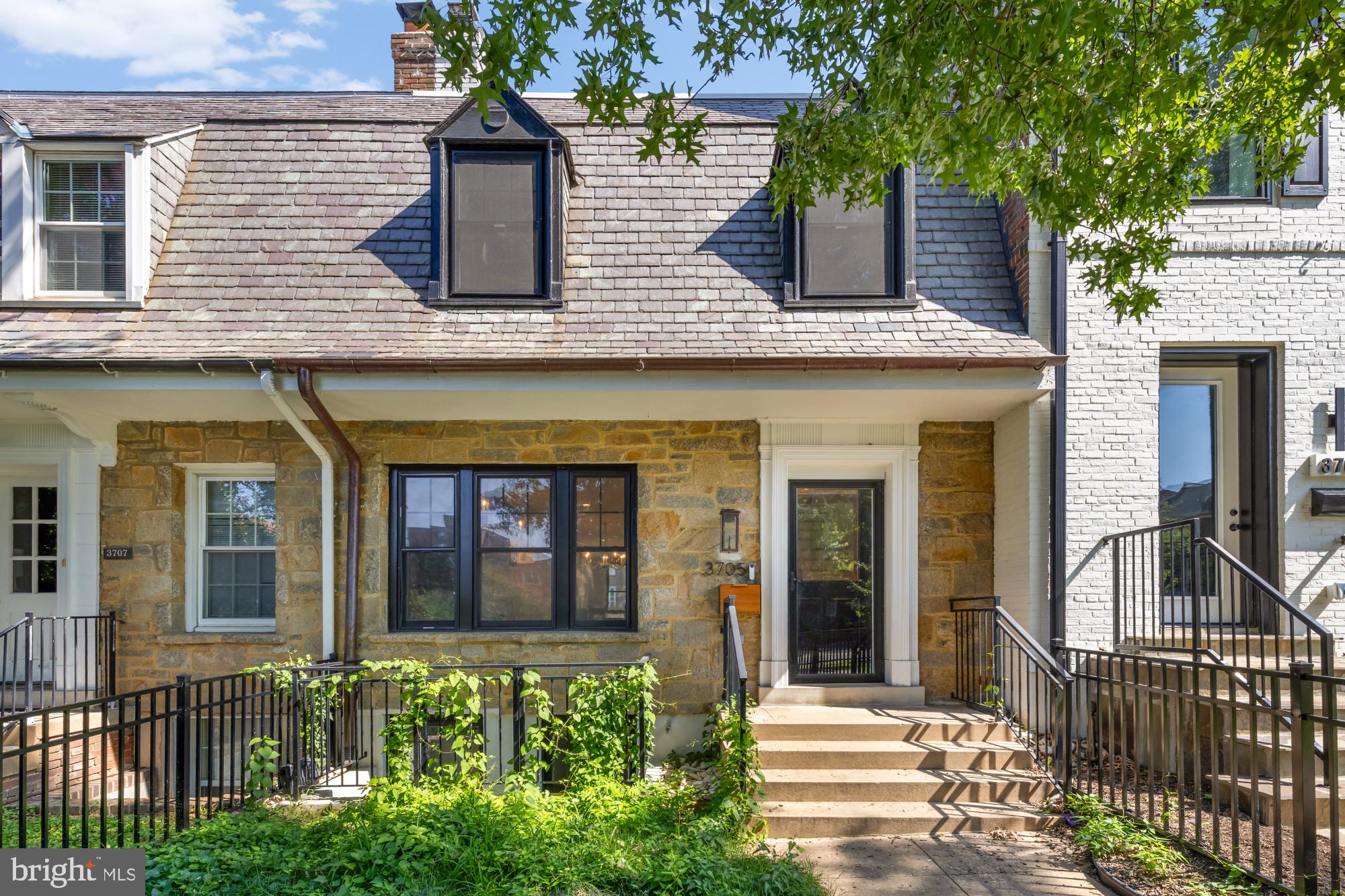 front view of a brick house with a small yard