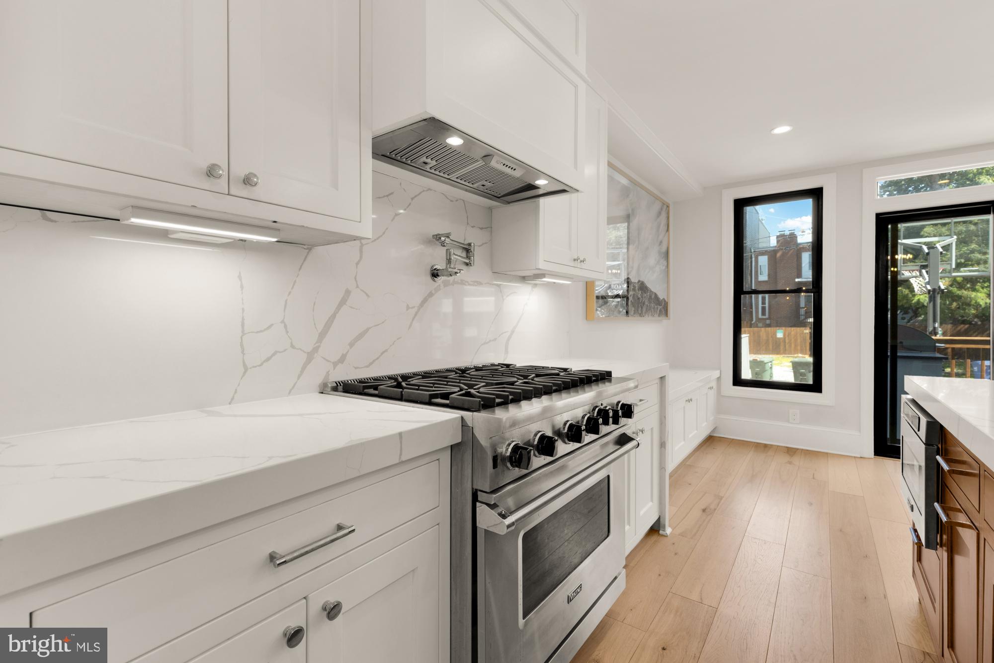 3705 Reservoir Road Northwest Washington, DC 20007 - Photo 18 of 45 a kitchen with granite countertop a stove and a wooden floor