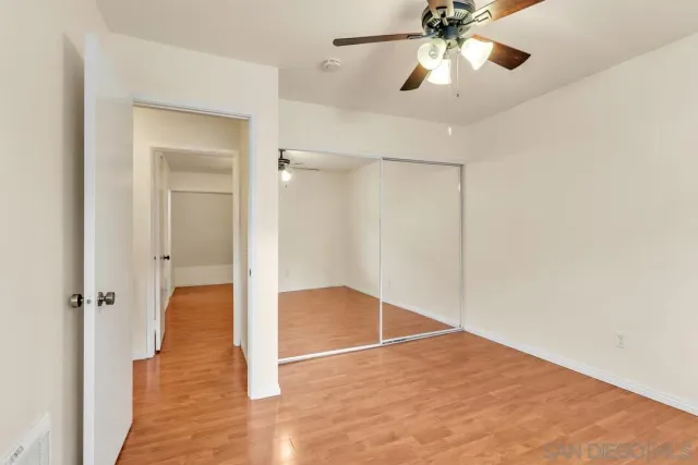 wooden floor in an empty room with a bathroom