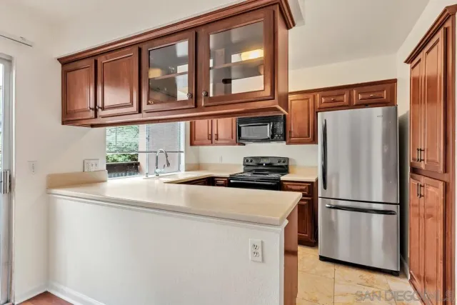a kitchen with stainless steel appliances granite countertop a refrigerator a stove and a sink with wooden floor