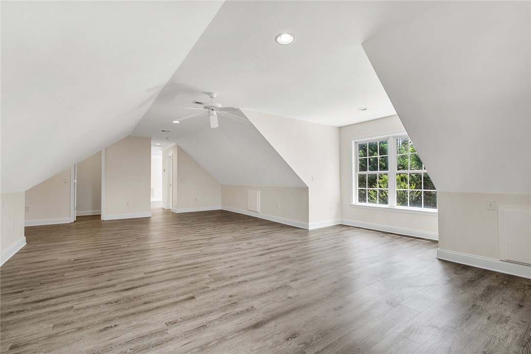 135 Sunset Bay Boulevard Seneca, SC 29672 - Photo 40 of 50 A spacious, airy bonus room with vaulted ceilings and abundant natural light from a large window.