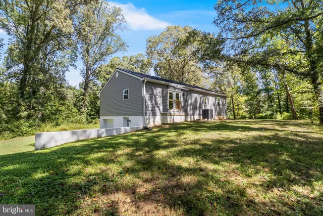 an aerial view of residential houses with outdoor space and trees all around