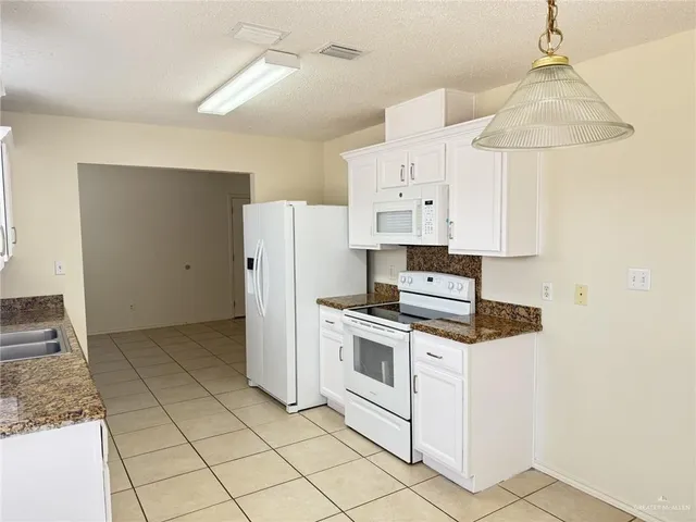 a kitchen with white cabinets and white appliances