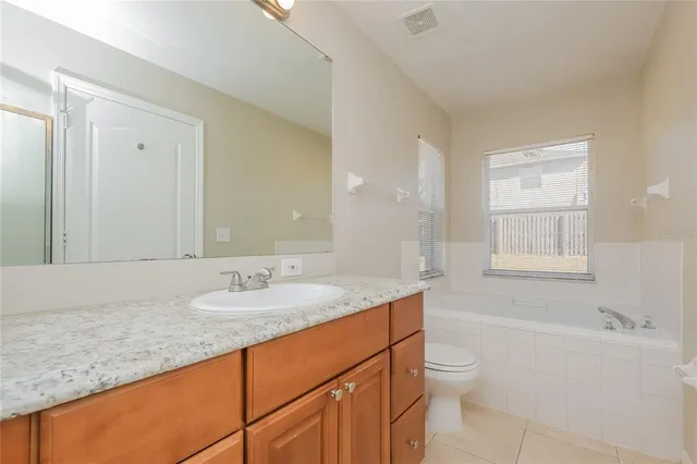 a bathroom with a granite countertop sink a toilet and shower