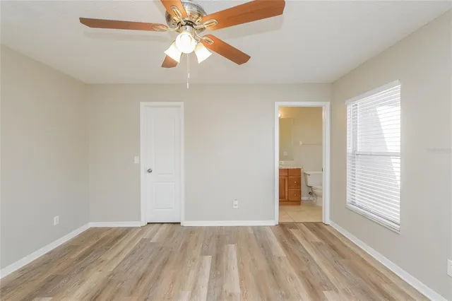 an empty room with closet and a ceiling fan