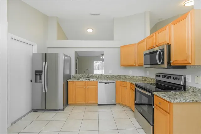 a kitchen with stainless steel appliances granite countertop a refrigerator and a stove top oven