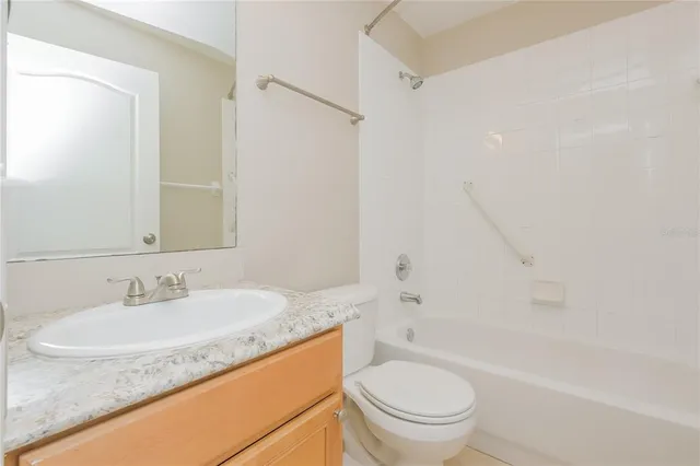a bathroom with a granite countertop sink a toilet and shower