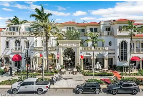a front view of a building with cars parked