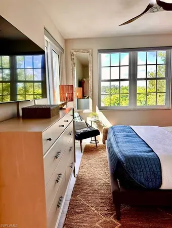 a bedroom with a bed and a large window