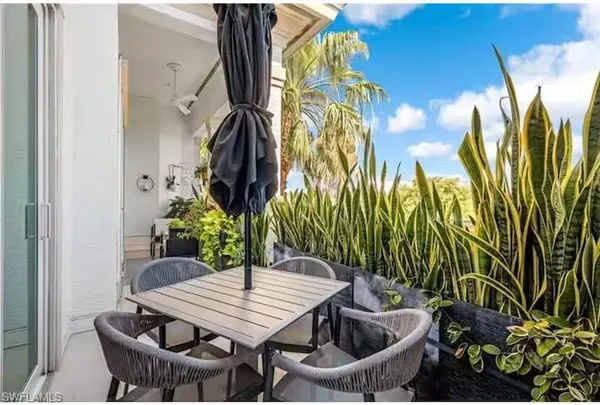 a table with chairs and a vase of flowers