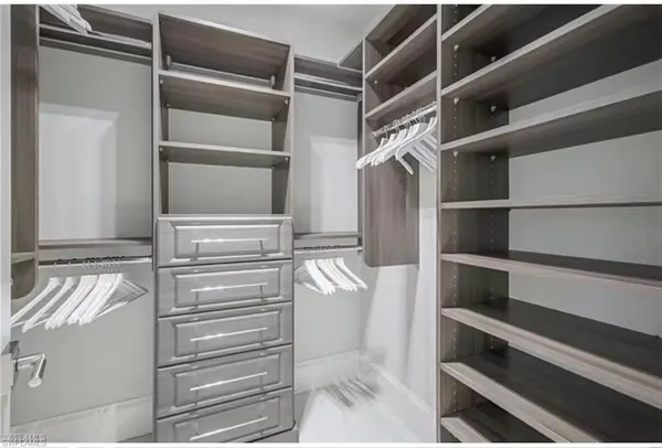 a view of walk in closet with empty racks