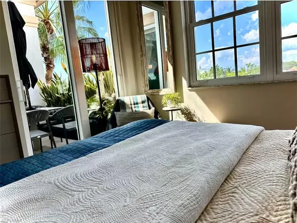 a bedroom with a bed and large windows