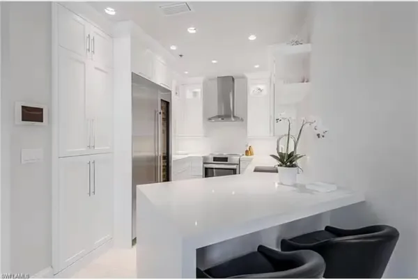 a kitchen with kitchen island a sink stainless steel appliances and cabinets