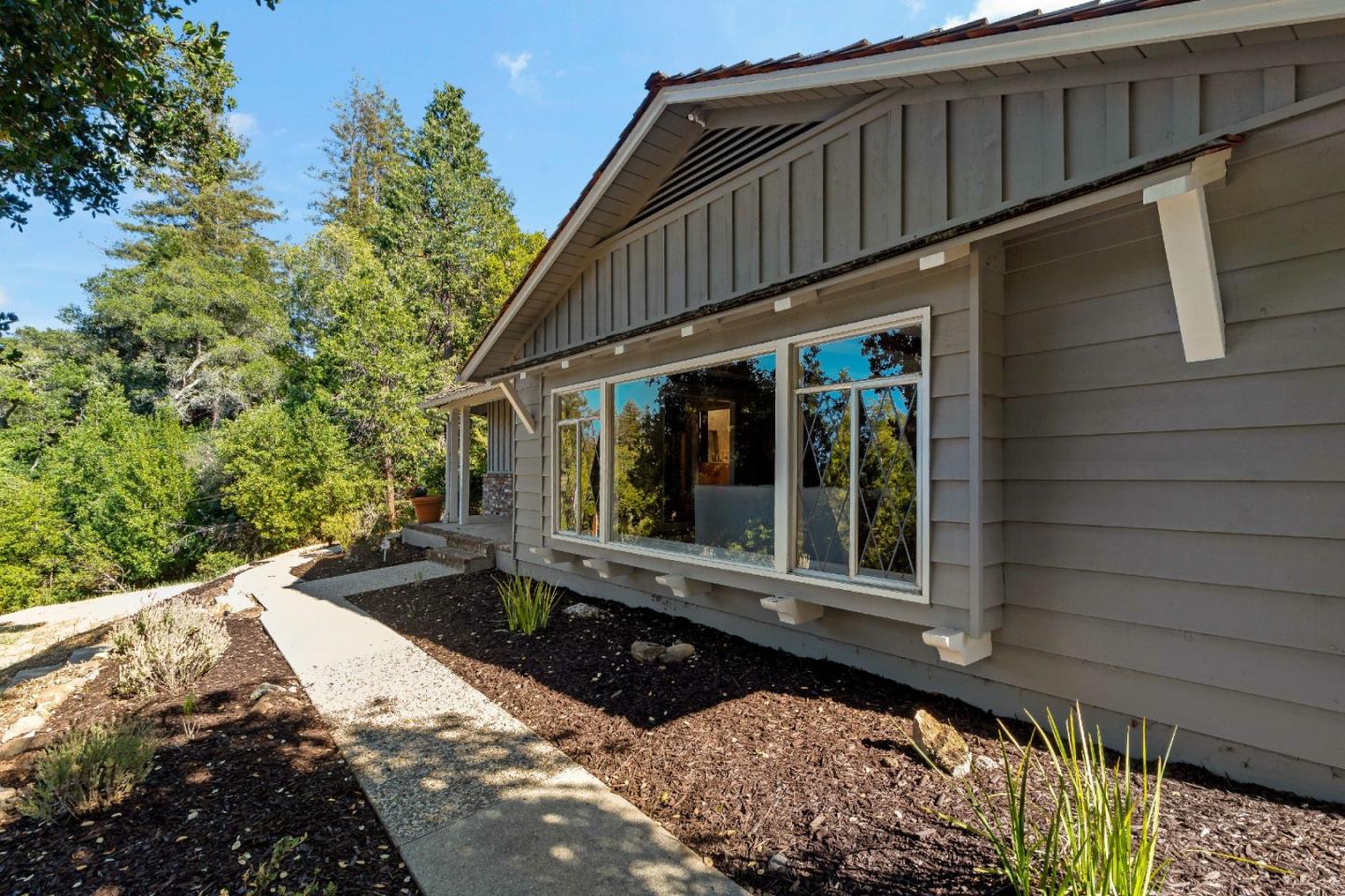 335 Harcross Road Woodside, CA 94062 - Photo 6 of 72 a view of a house with a large window and flower plants