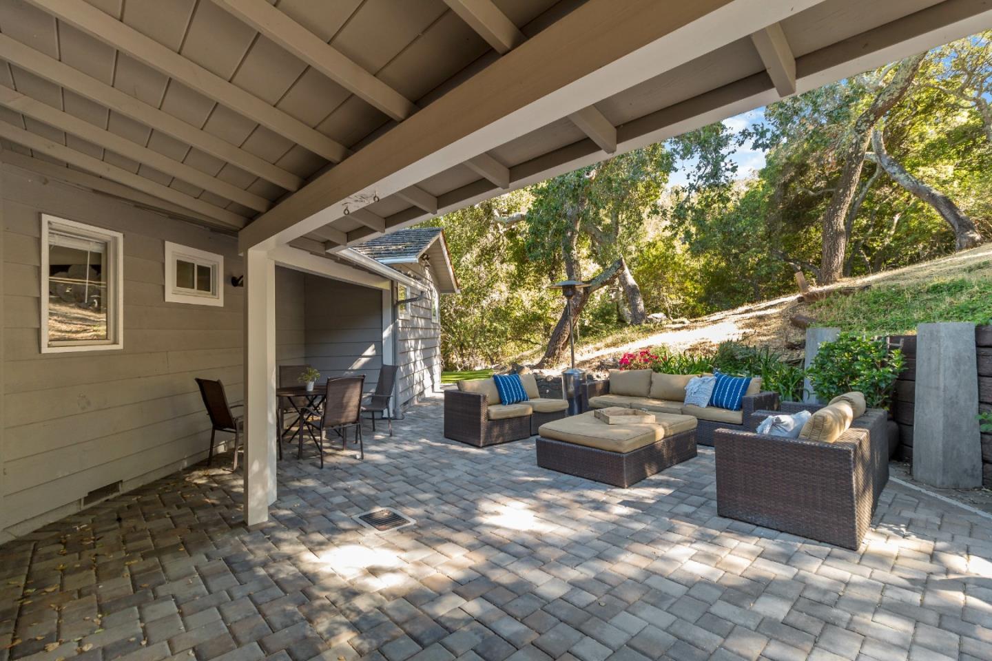 335 Harcross Road Woodside, CA 94062 - Photo 54 of 72 a view of a patio with couches and chairs under an umbrella next to a yard