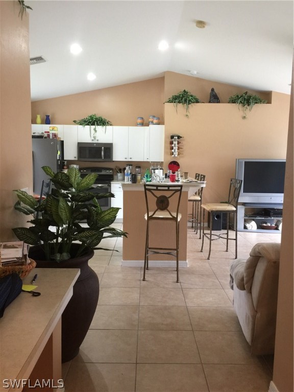 3115 Meadow Road Lehigh Acres, FL 33974 - Photo 11 of 23 a living room with furniture a flat screen tv and a table