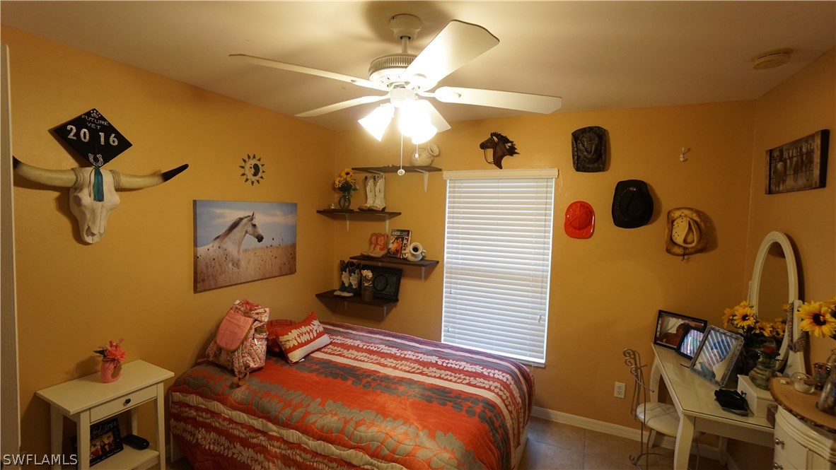 3115 Meadow Road Lehigh Acres, FL 33974 - Photo 14 of 23 a bedroom with a bed and a chandelier
