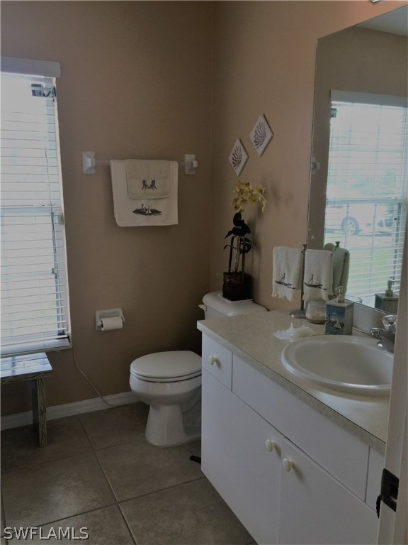 3115 Meadow Road Lehigh Acres, FL 33974 - Photo 17 of 23 a bathroom with a toilet sink vanity and mirror