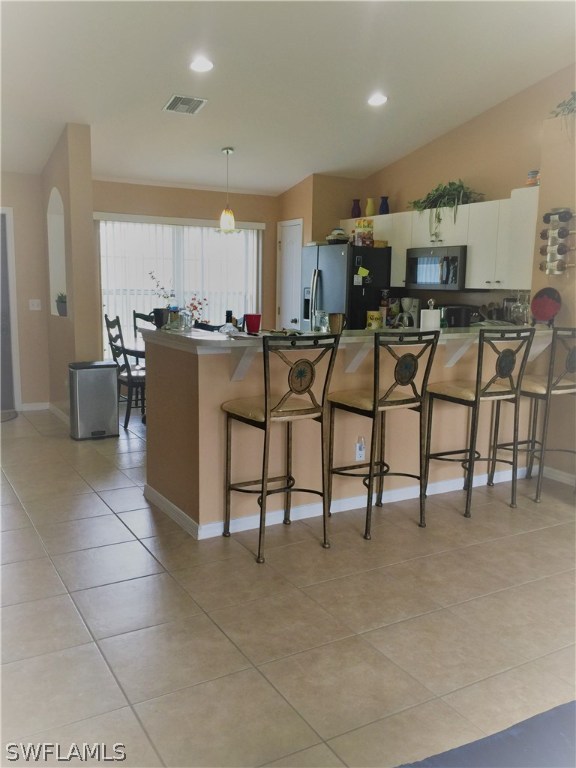 3115 Meadow Road Lehigh Acres, FL 33974 - Photo 8 of 23 a kitchen with stainless steel appliances kitchen island granite countertop a table chairs and a refrigerator