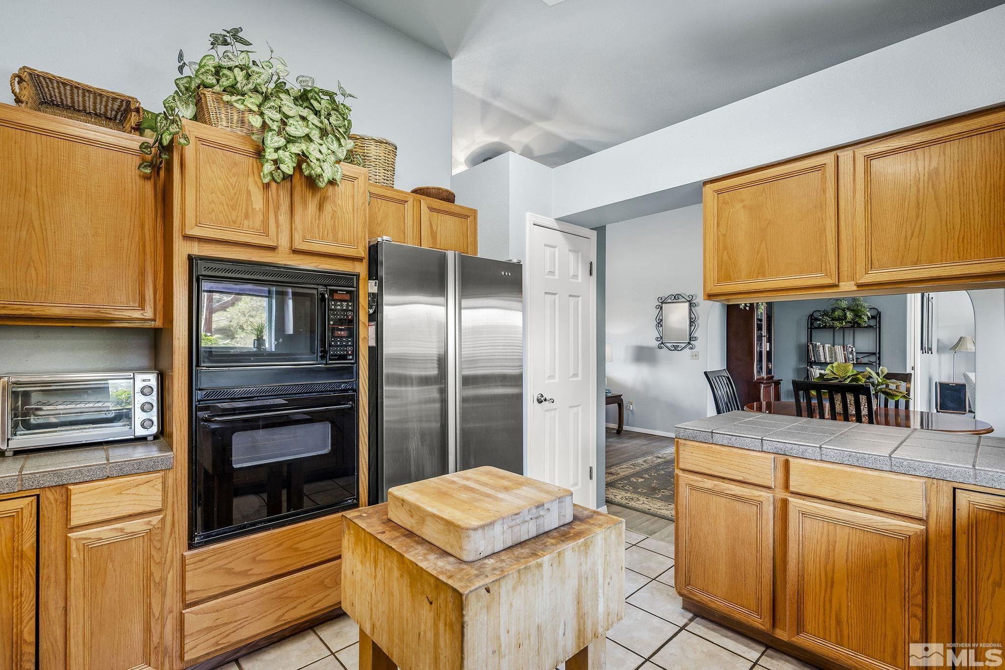1090 Lavender Way Reno, NV 89521 - Photo 8 of 22 a kitchen with stainless steel appliances granite countertop a refrigerator and a stove top oven