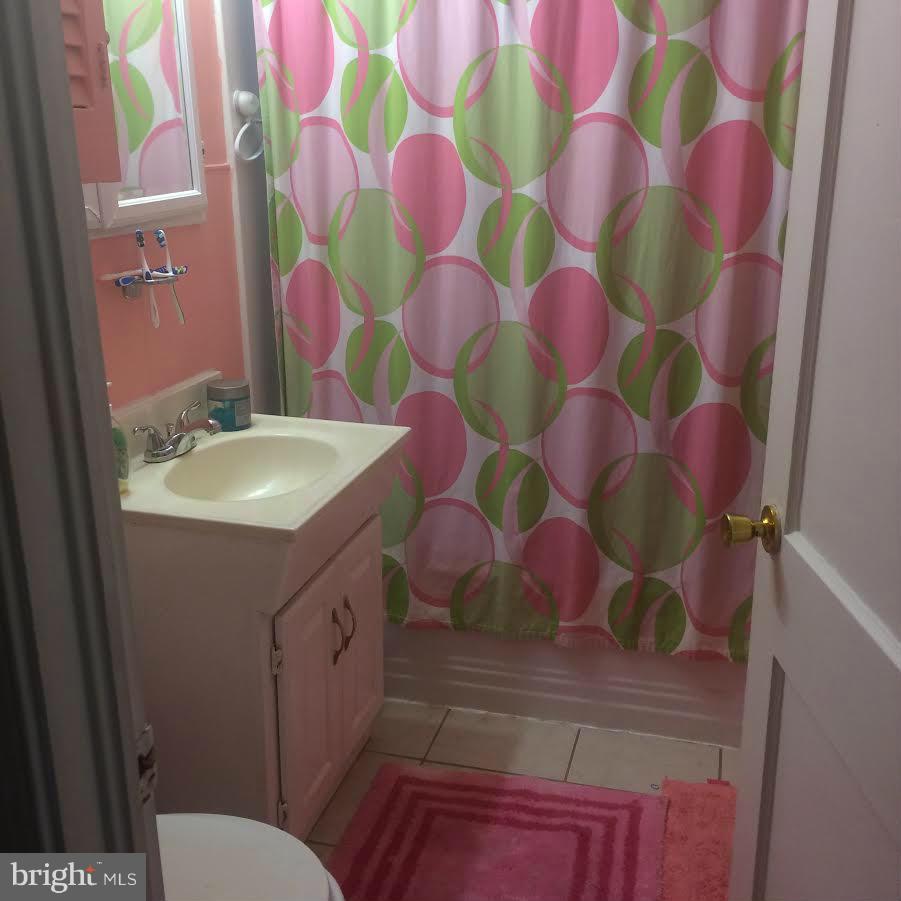 6505 Woodley Road Clinton, MD 20735 - Photo 12 of 12 a bathroom with a sink and mirror with toilet