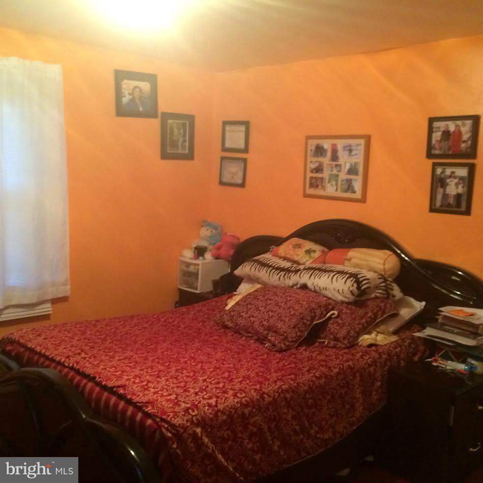 6505 Woodley Road Clinton, MD 20735 - Photo 3 of 12 a bedroom with a bed and painting on the wall