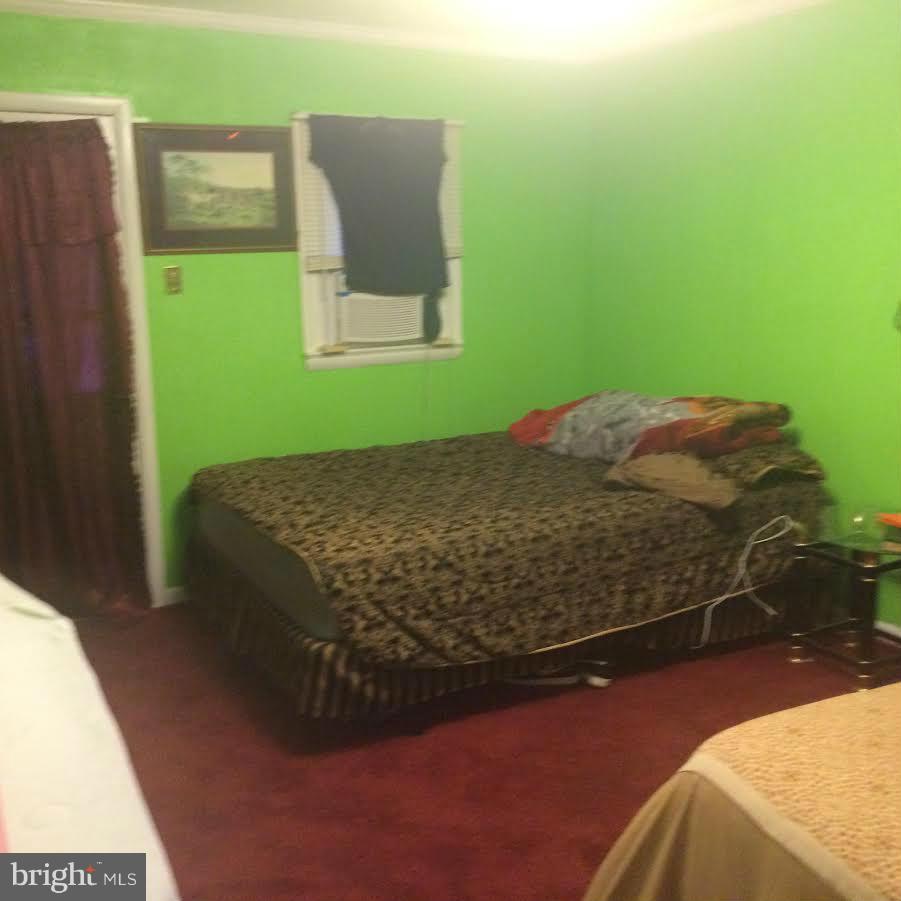 6505 Woodley Road Clinton, MD 20735 - Photo 9 of 12 a bed sitting in a bedroom next to a window