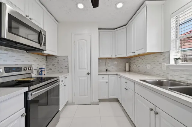 a kitchen with white cabinets stainless steel appliances and sink