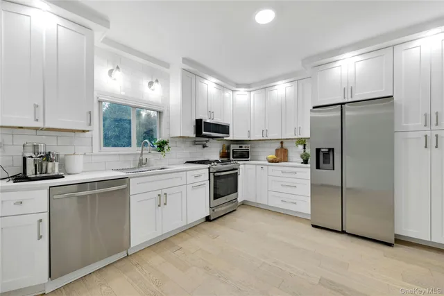 a kitchen with white cabinets and stainless steel appliances