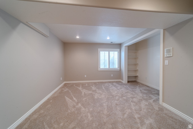 598 Hollow Creek Road Draper, UT 84020 - Photo 45 of 110 Spacious room featuring plush carpeting, recessed lighting, a window with plantation shutters, an integrated shelving unit, and neutral wall tones