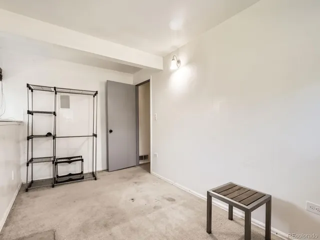 an empty room with windows and fireplace