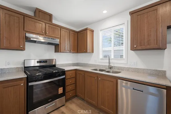 a kitchen with stainless steel appliances granite countertop a sink stove and cabinets