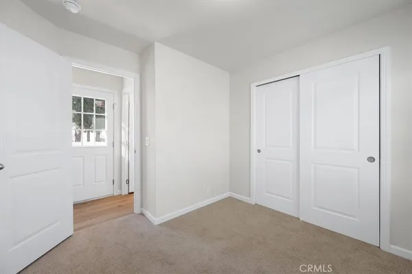 a view of an empty room with closet and a window