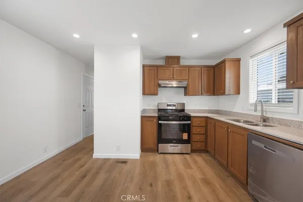 a kitchen with stainless steel appliances granite countertop a stove a sink and a refrigerator