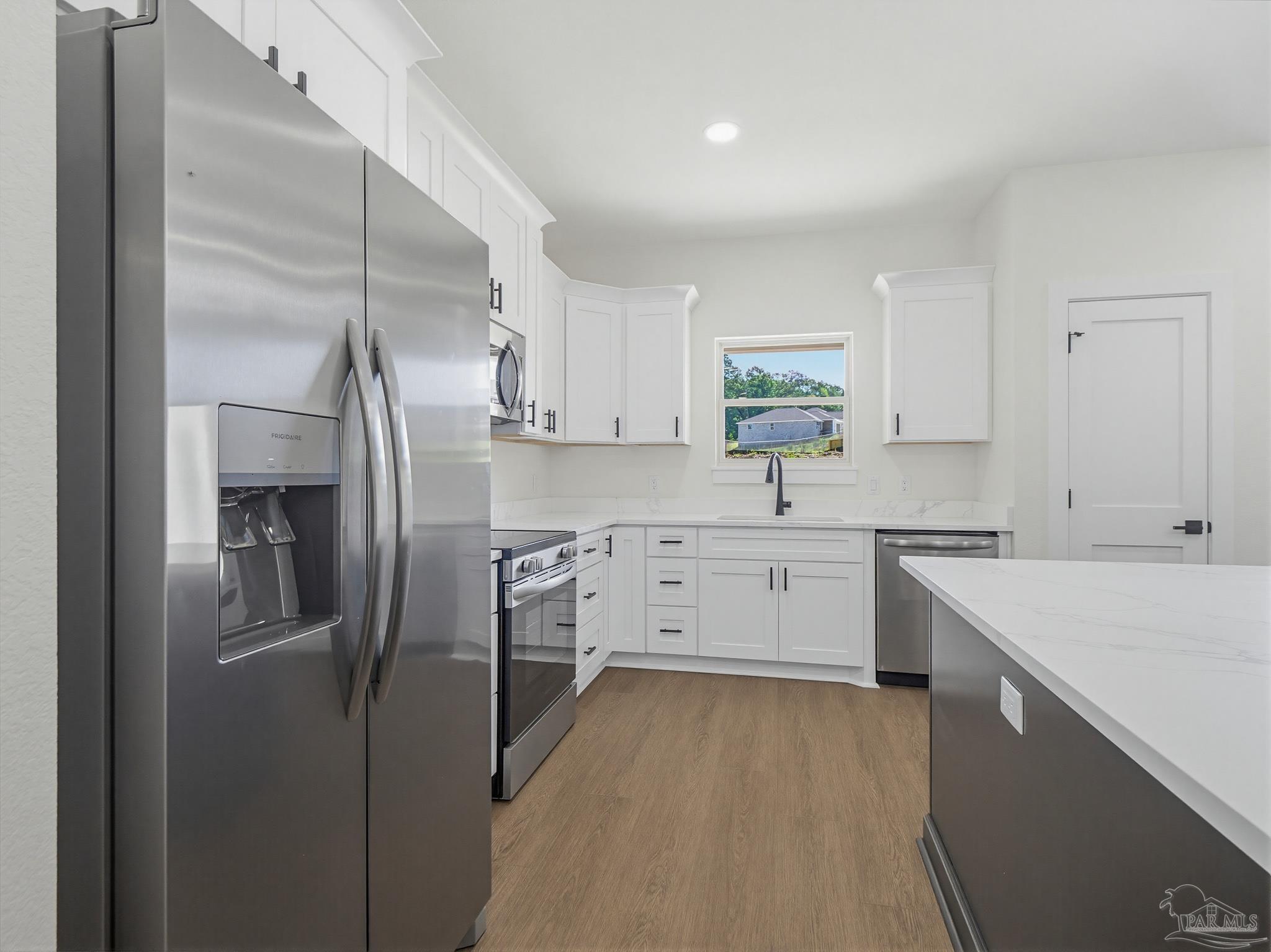 5724 Riviera Drive Milton, FL 32583 - Photo 17 of 52 a kitchen with white cabinets and stainless steel appliances